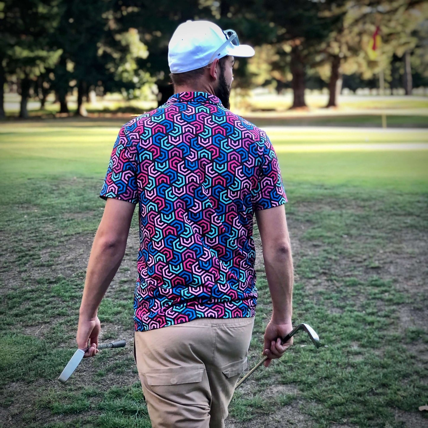 Male Golfer Walking with clubs wearing Geometric Swirl Swing Golf Polo